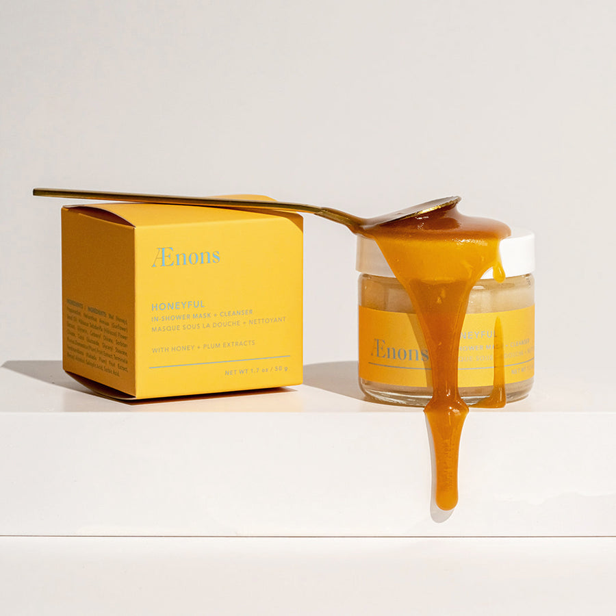 In-shower honey mask showing honey dripped onto the jar with a spoon resting on top.