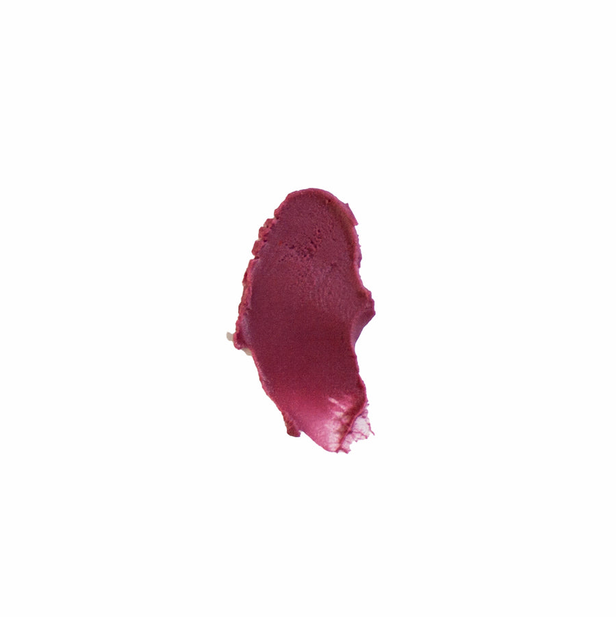Swatch of tinted lip balm in a deep berry color.
