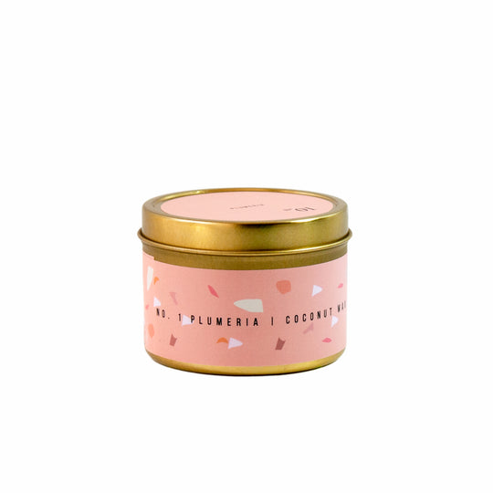 Pink plumeria and jasmine scented travel candle in gold tin can.